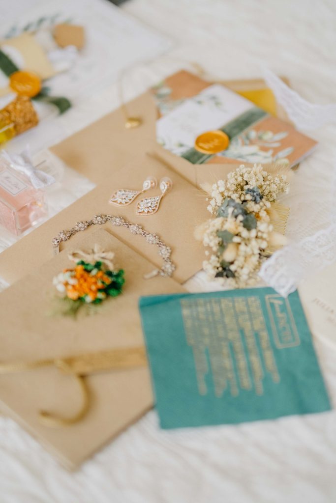 Flatlay mit Papeterie, Schmuck und Blumen der Hochzeit von Julia im Kloster Kaul