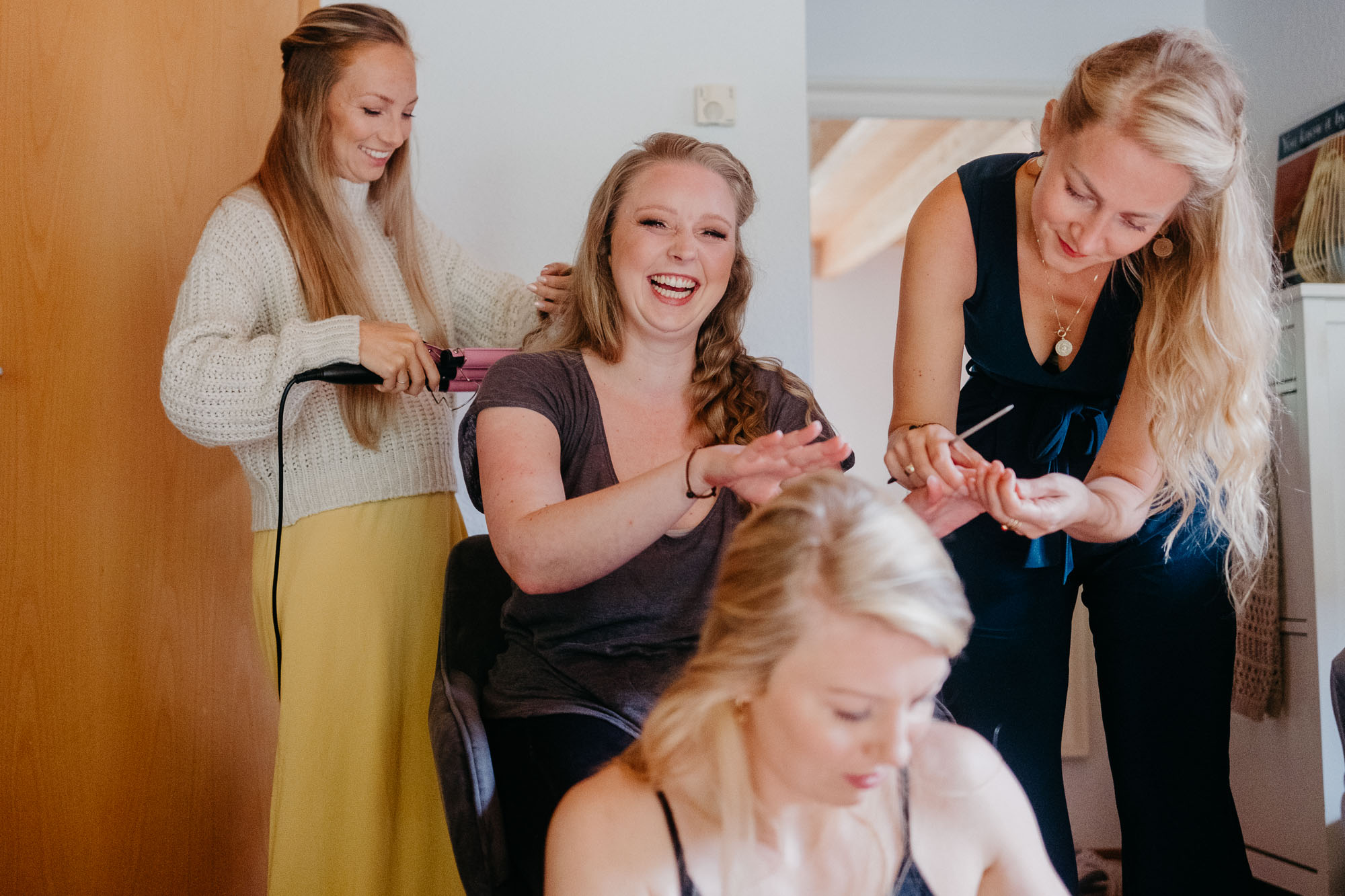 Braut Bea wird am Morgen von ihrer Schwester und den Brautjungfern für die Hochzeit gestylt.