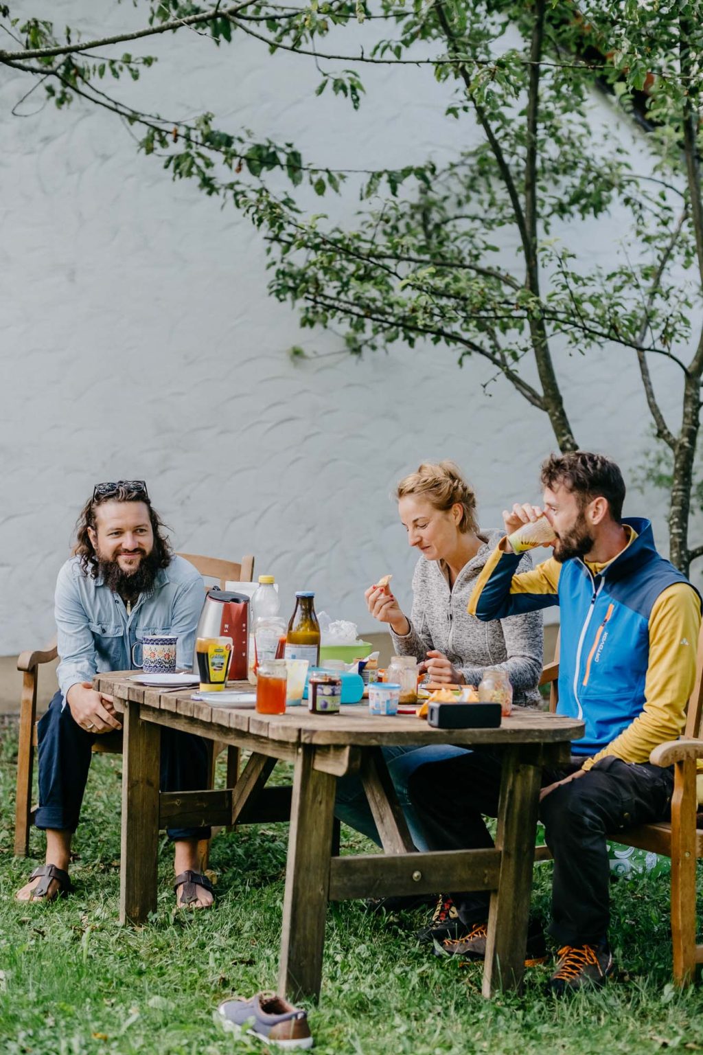 Freunde frühstücken im Garten bei Kaffee und Sonne