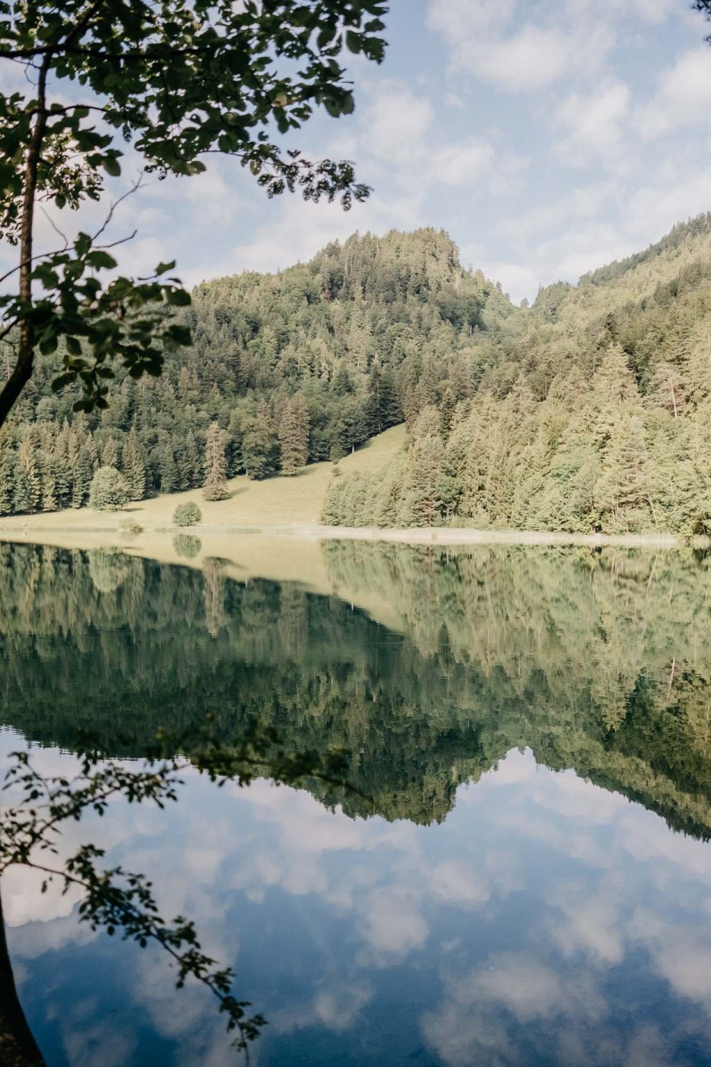 Alatsee mit Spiegelung der Berge im Wasser