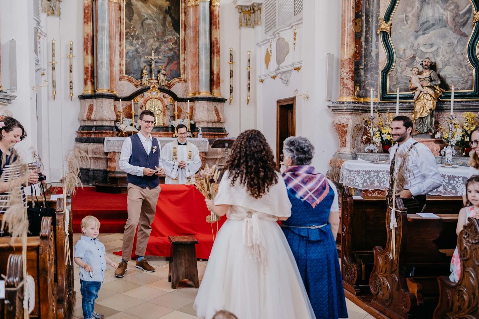 Braut und Mutter von hinten, vorne der wartende Bräutigam