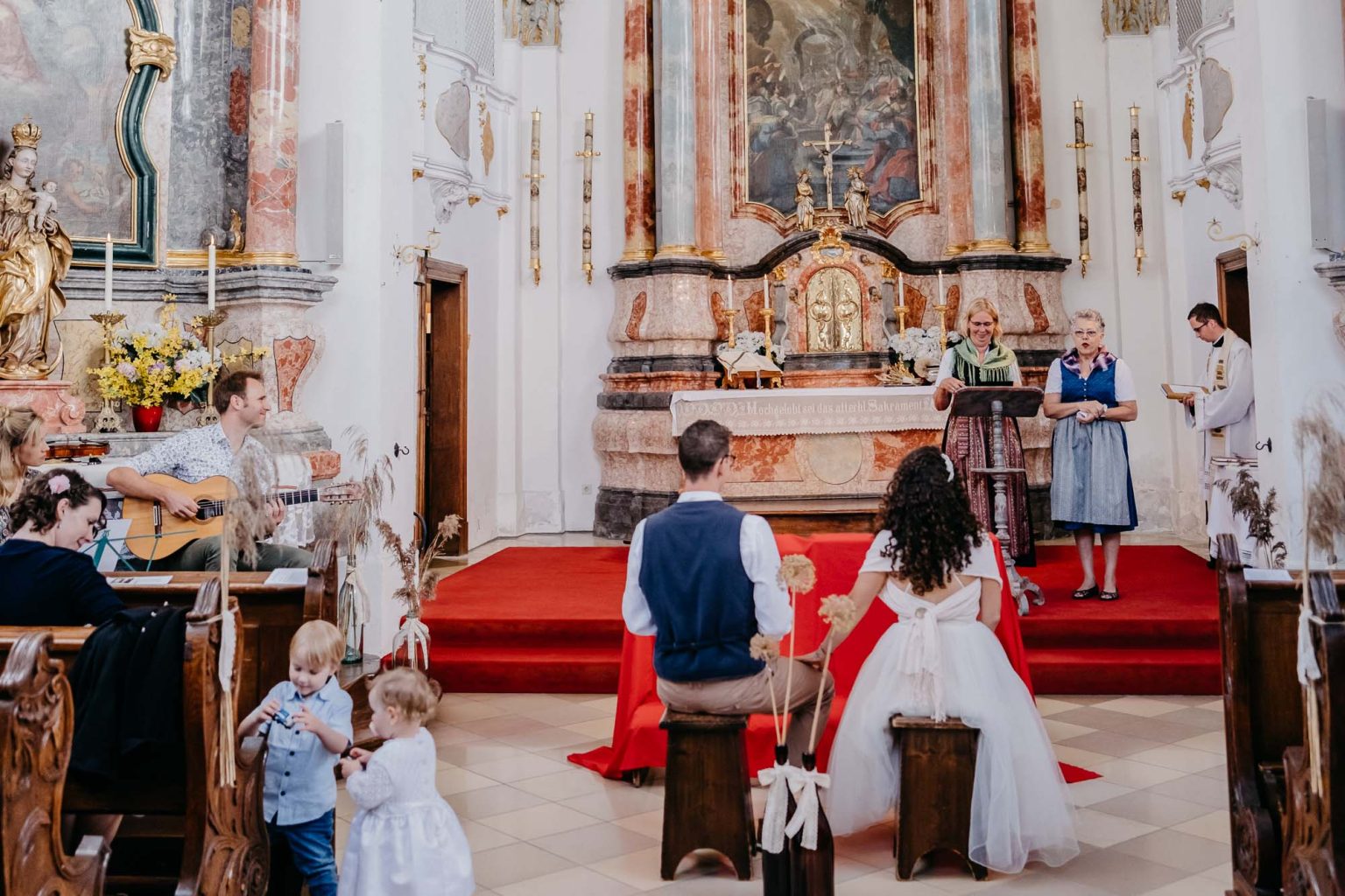 Brautpaar unscharf im Vordergrund, Mütter am Altar im Fokus