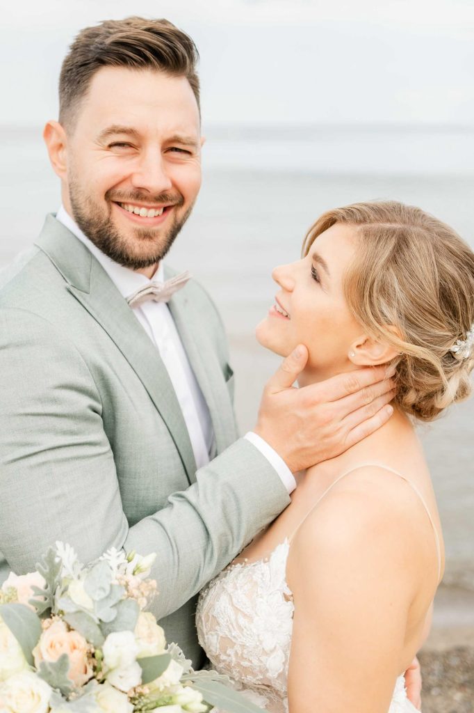 Brautpaar am Timmendorfer Strand, lachend und innig umarmt nach der Trauung, Hochzeitsfotograf Norddeutschland