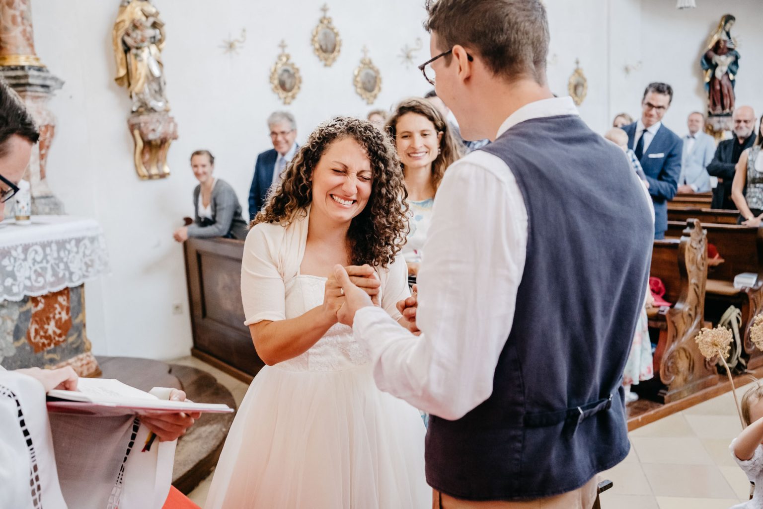 Braut und Bräutigam stehen sich am Altar gegenüber beim Gelübde