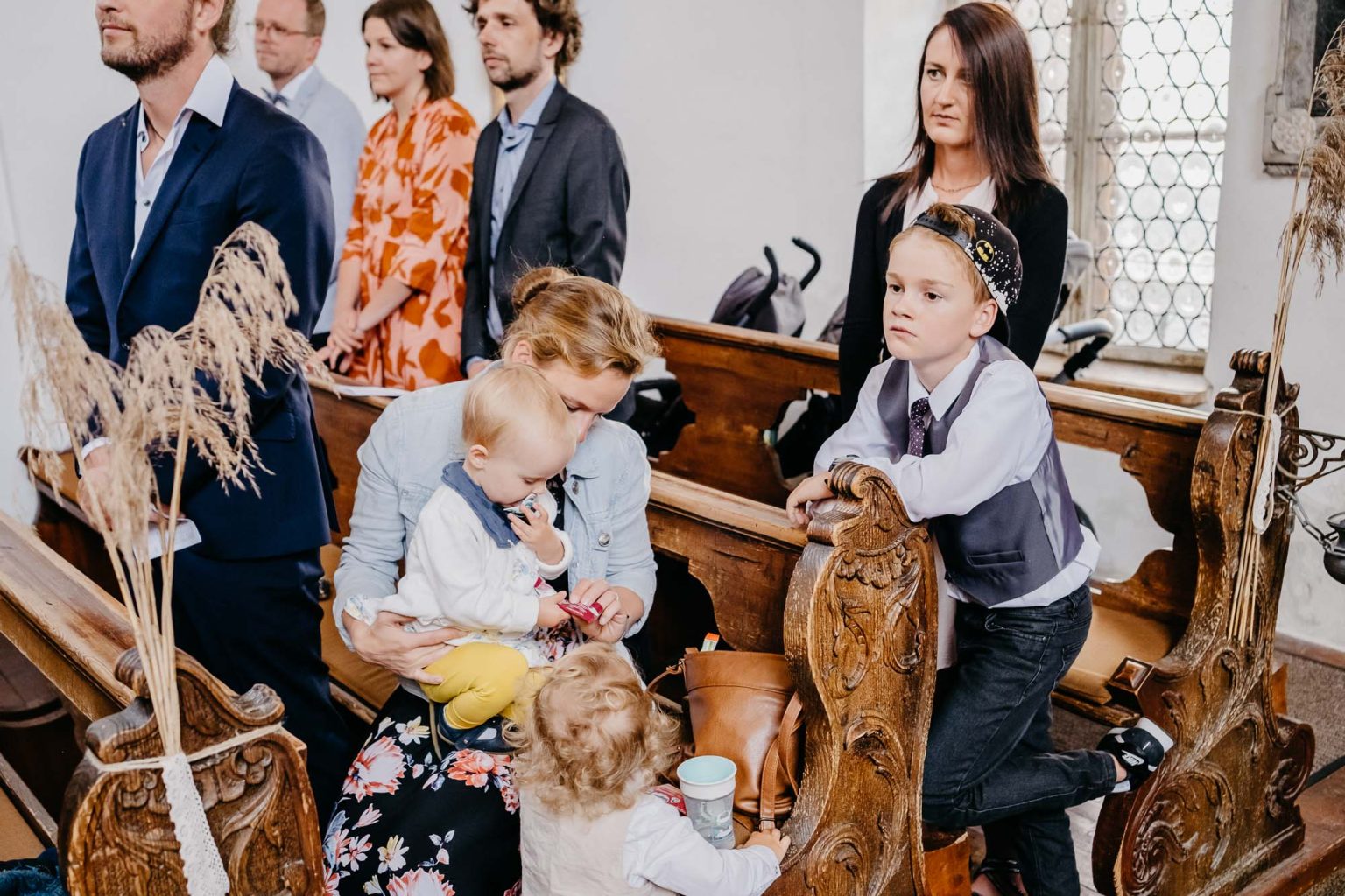 Gäste und Kinder sitzen in der Spitalkirche Heilig Geist während der Trauung