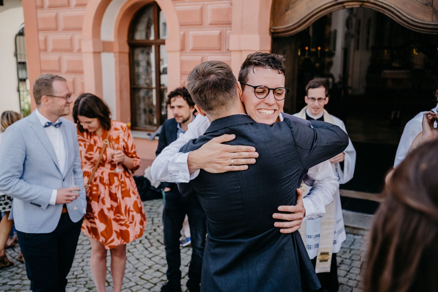 Freund nimmt den Bräutigam freudestrahlend in den Arm