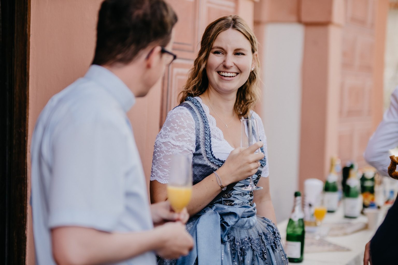 Freundin im Dirndl unterhält sich mit dem Pfarrer.