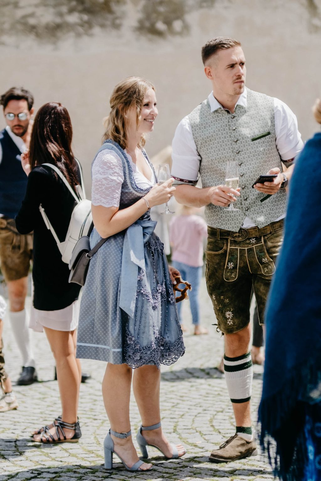 Paar in Tracht beim Sektempfang.