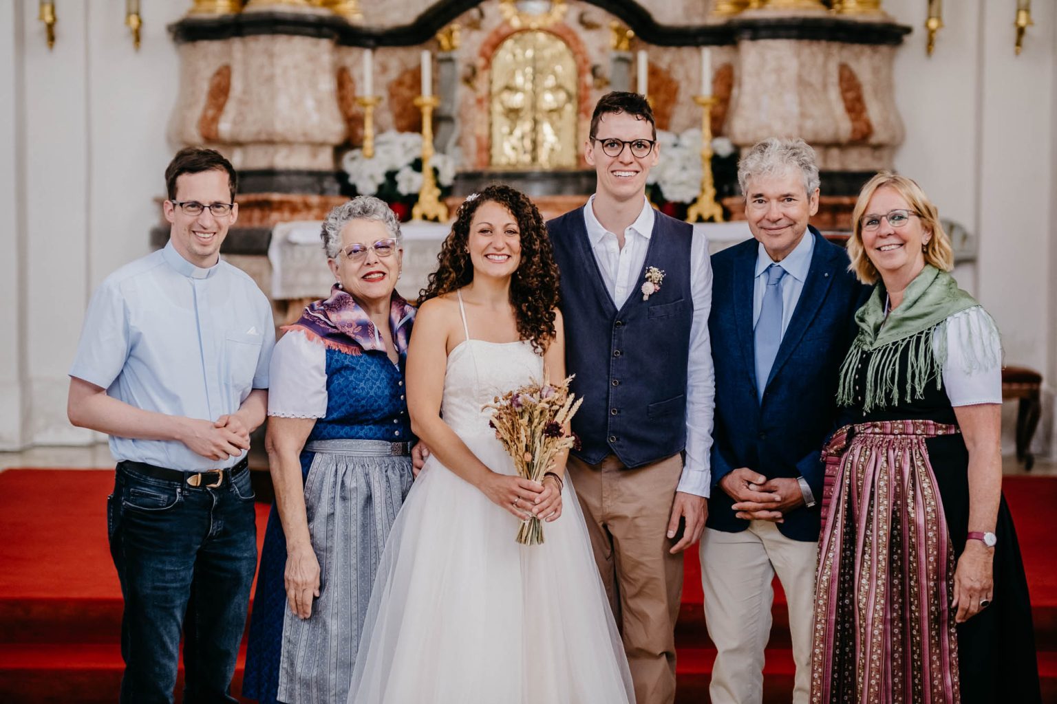 Brautpaar mit Eltern und Pfarrer in der Spitalkirche Heilig Geist.