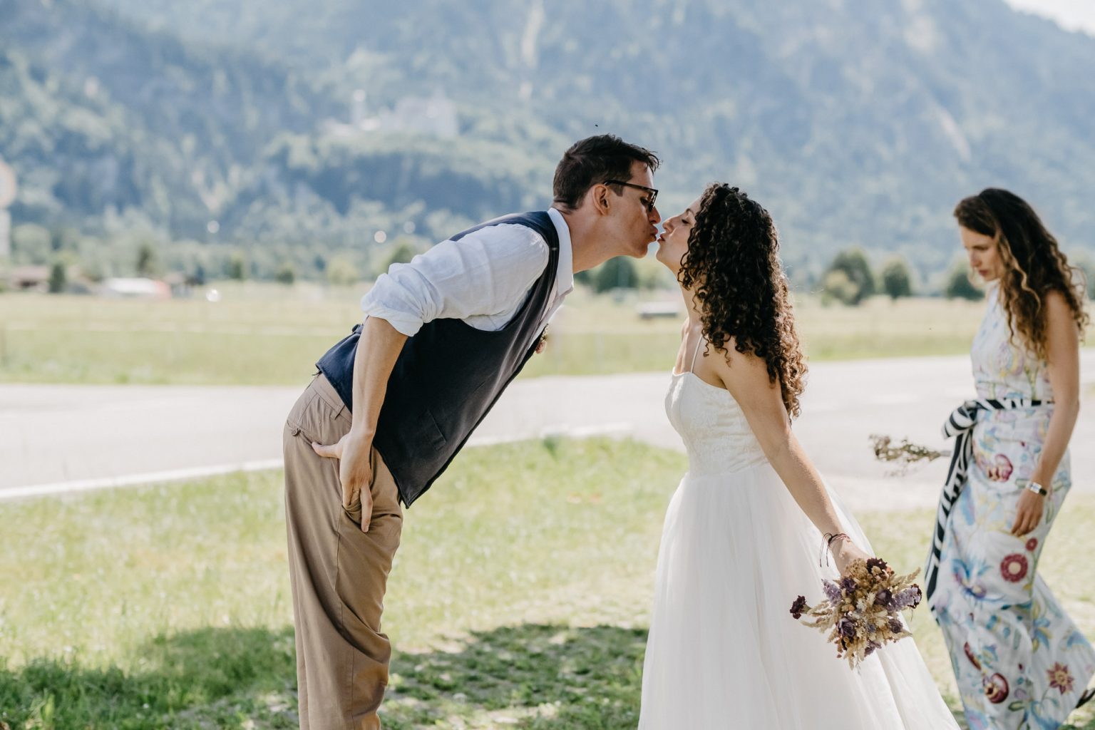 Brautpaar küsst sich mit Blick auf Schloss Neuschwanstein.