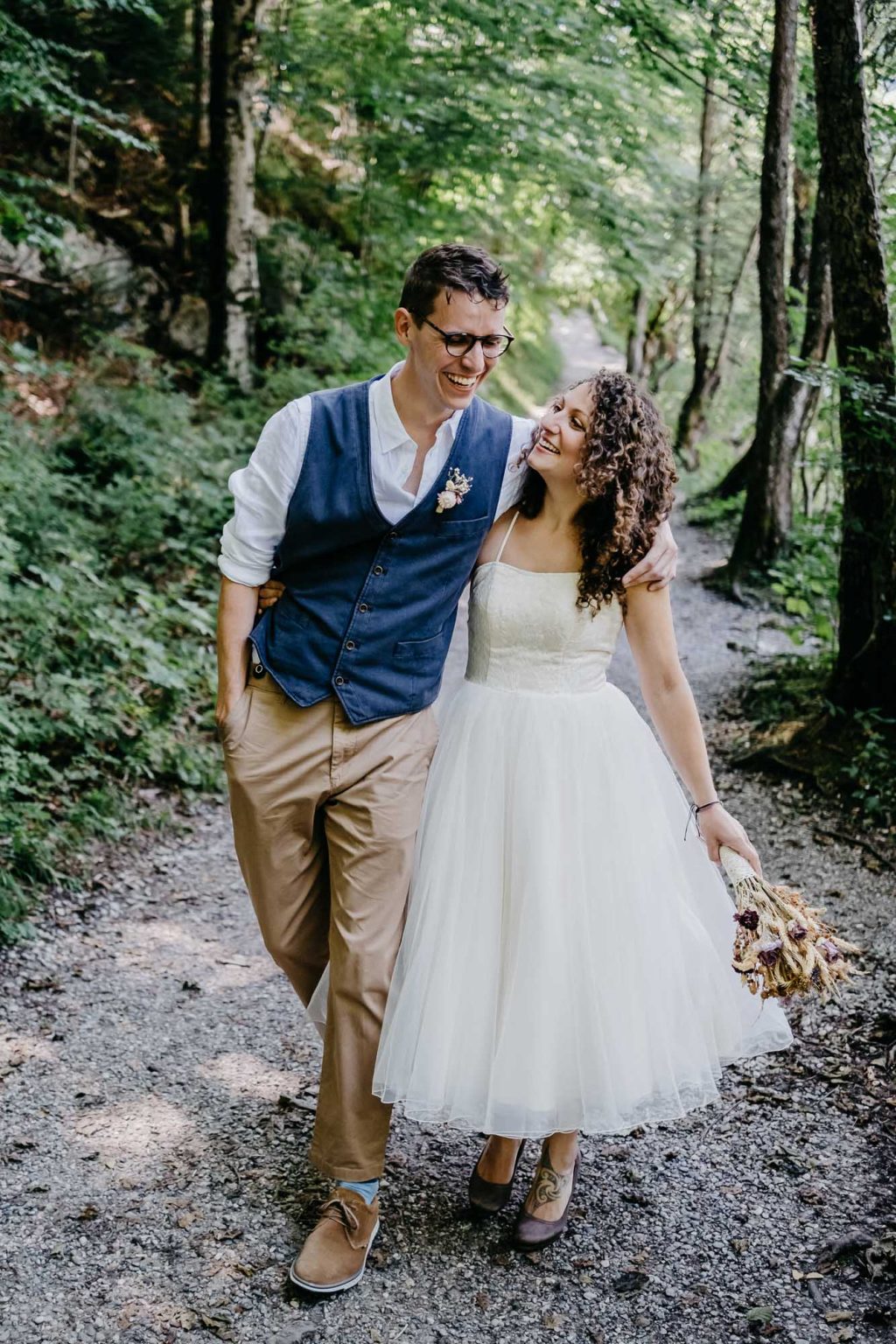 Hochzeitsfotos am Alatsee – Brautpaar in Bewegung, umarmt beim Spaziergang durch den Wald