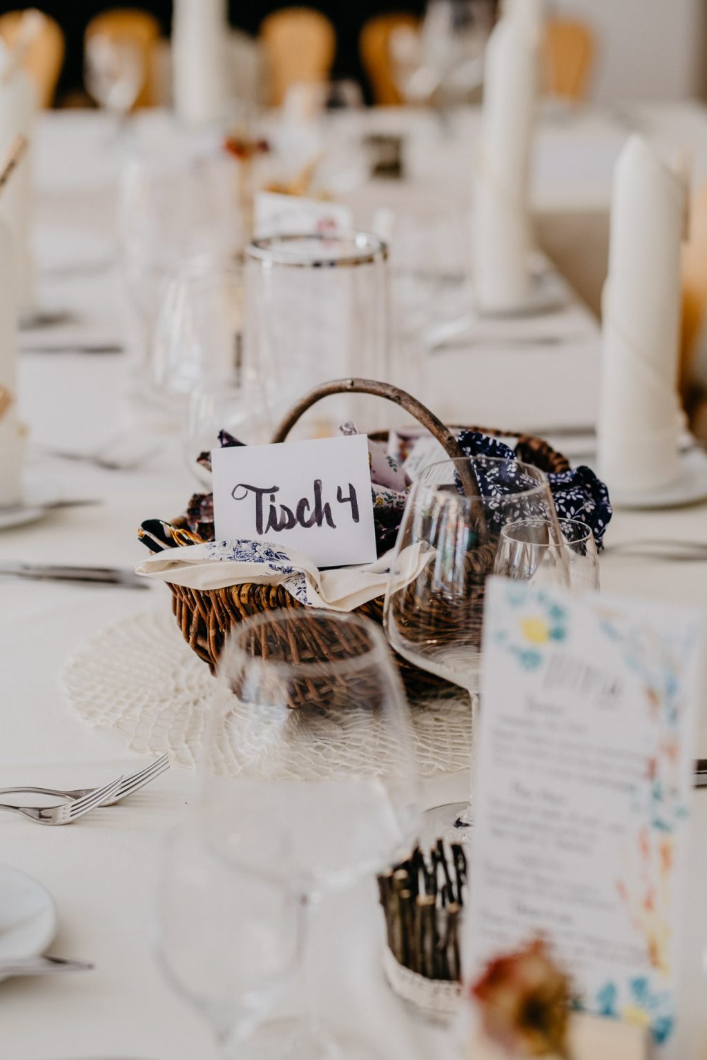 Hochzeitstischdeko mit Körbchen, Gastgeschenken und Tischnummer im Hotel Alatsee