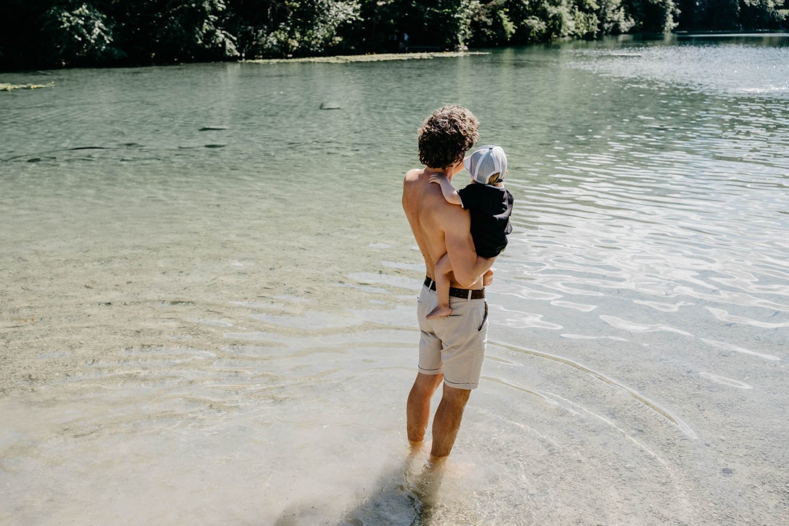 Freund des Brautpaars steht oben ohne mit Sohn im Wasser am Alatsee