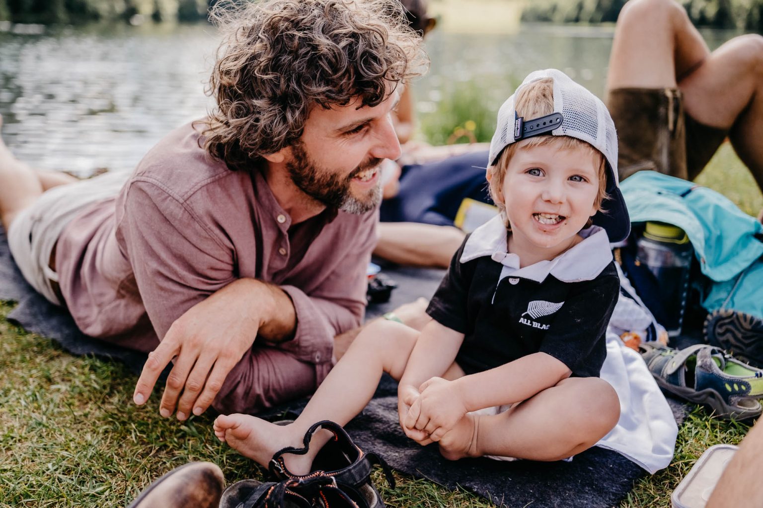 Vater mit Sohn auf Decke am Ufer des Alatsee bei Hochzeitsfeier