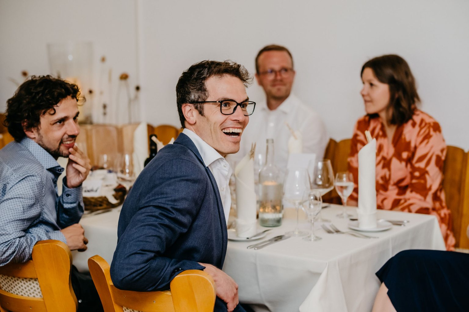 Gäste lachen bei Rede des Brautpaars während Hochzeitsfeier im Hotel Alatsee