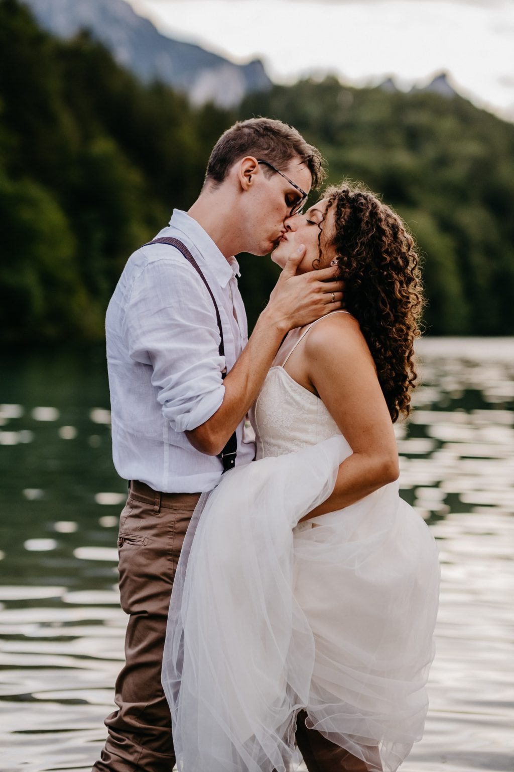 Nahaufnahme des Kusses im See bei der Hochzeit in Füssen