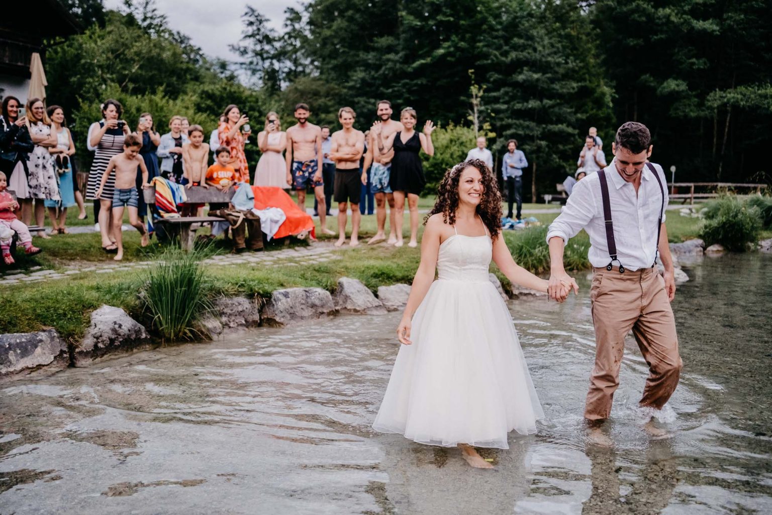Hochzeitspaar geht langsam in den Alatsee bei Füssen