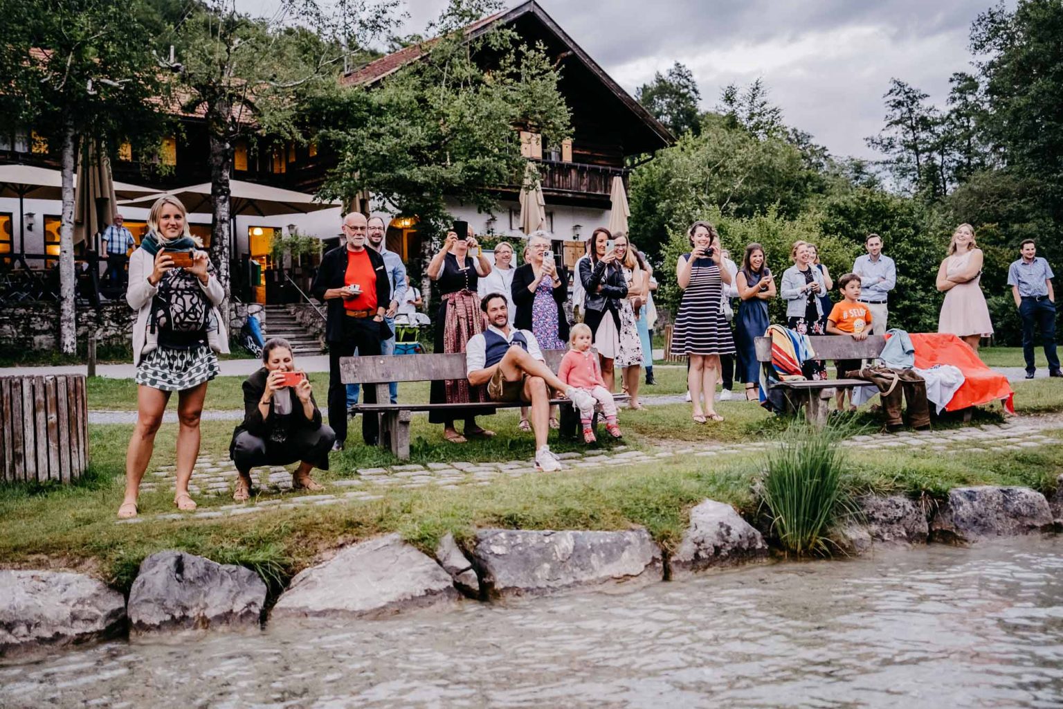 Hochzeitsgesellschaft schaut auf das Geschehen im See am Alatsee
