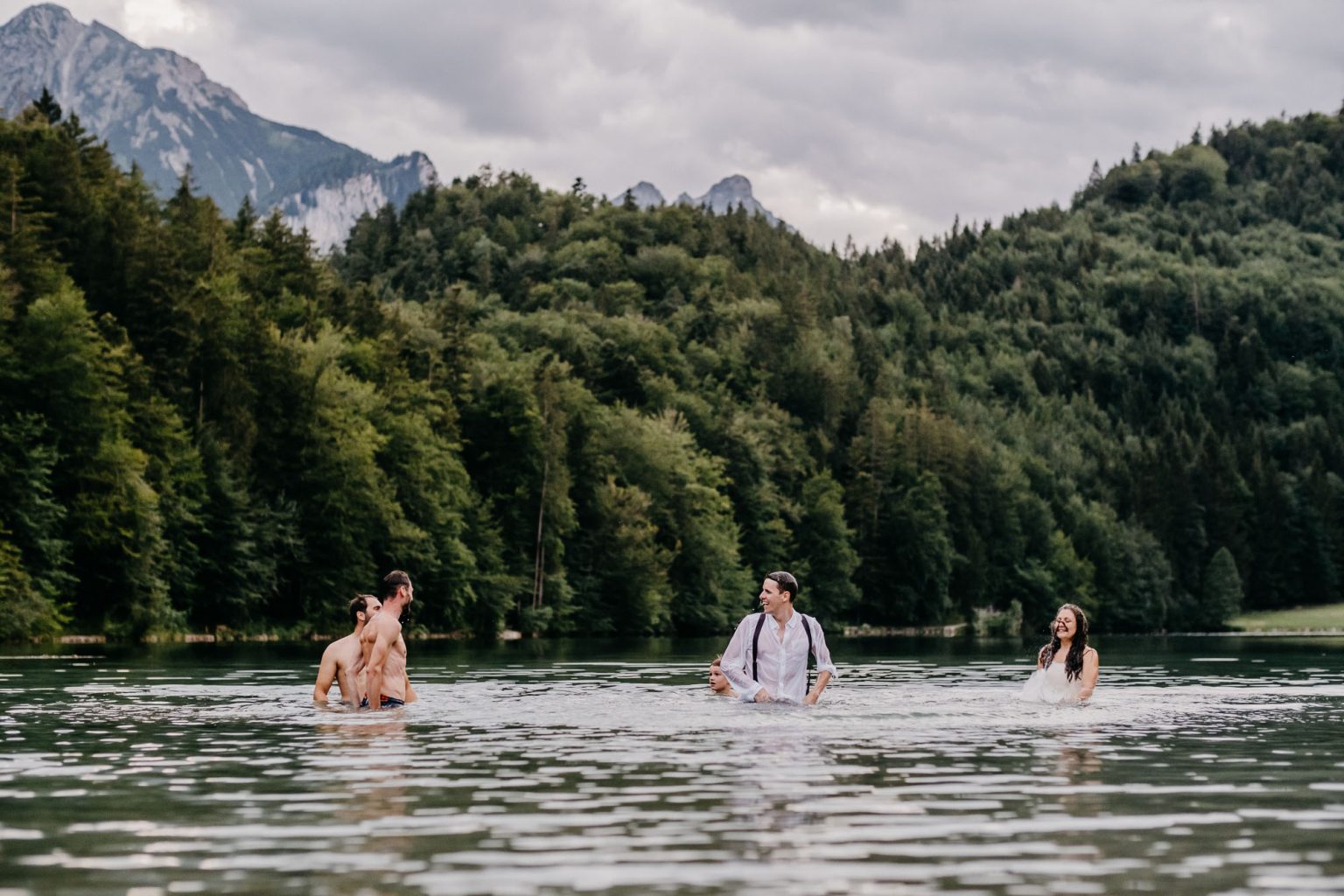 Brautpaar und Freundin im See, Bergpanorama im Hintergrund