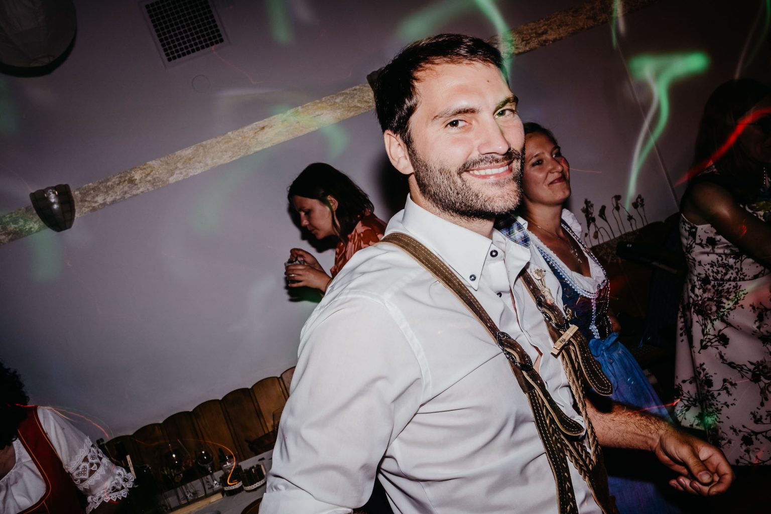 Trauzeuge in Lederhose tanzt bei der Hochzeit im Hotel Alatsee, Allgäu.