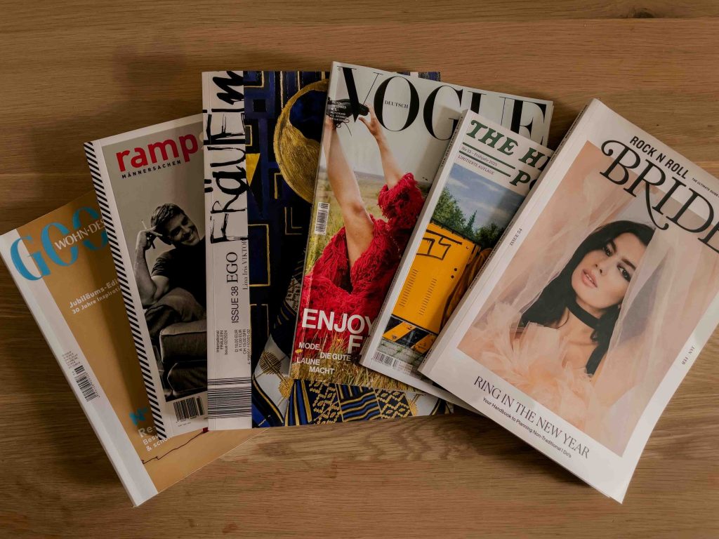 Verschiedene Design- und Lifestyle-Magazine auf einem Tisch: Goodlife WohnDesign, rampstyle, Fräulein, Vogue, The Heritage Post und Rock n Roll Bride als Inspirationsquelle für Familienmagazine.