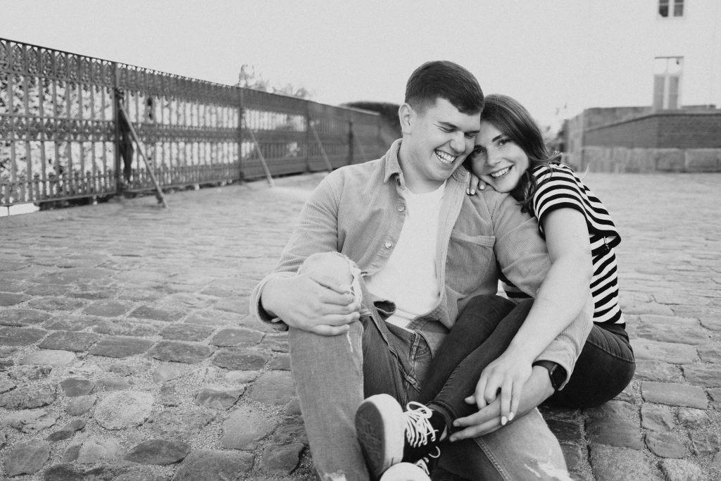 Verlobungsshooting eines Paares, das am Schloss Plön miteinander lacht – authentischer Moment beim Engagement-Shooting