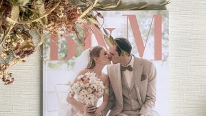 Flatlay eines individuellen Hochzeitsmagazins mit Trockenblumen und Stoff – Beispiel für ein emotionales Erinnerungsstück