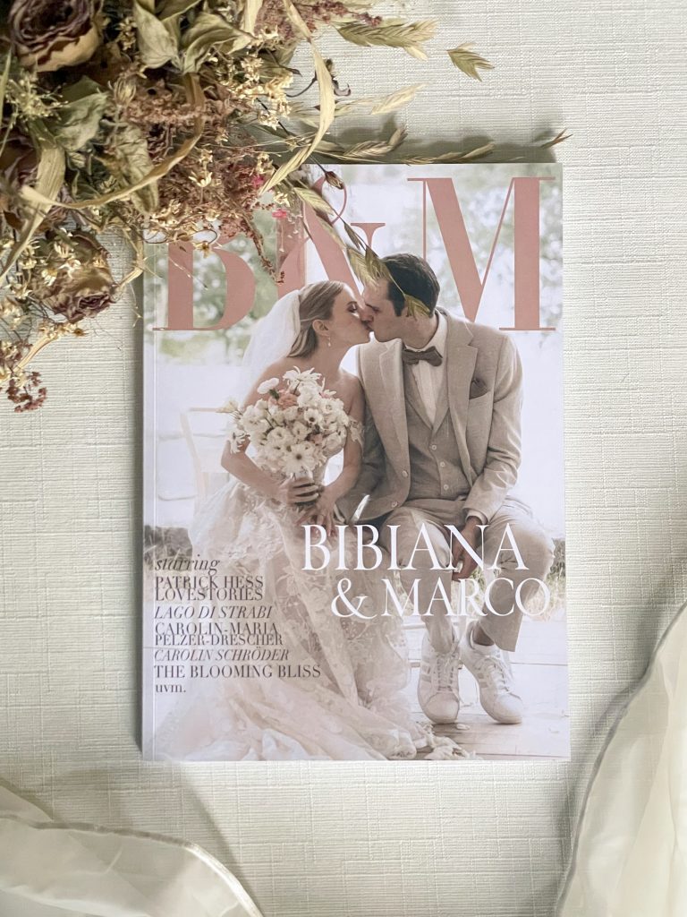 Flatlay eines individuellen Hochzeitsmagazins mit Trockenblumen und Stoff – Beispiel für ein emotionales Erinnerungsstück